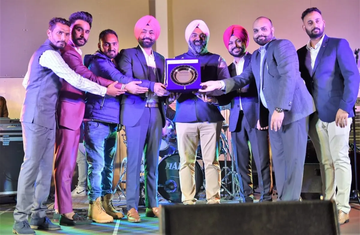 Club members in suits present a commemorative plaque on stage